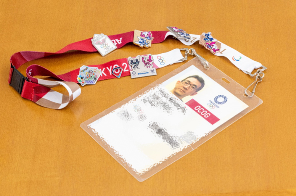 His staff ID strap is covered in badges he exchanged with the other volunteers and the event staff.